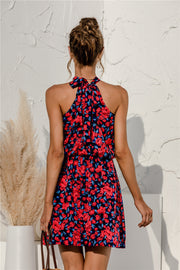 Halter neckline mini dress in dark navy with red and blue floral print, tie back detail.
