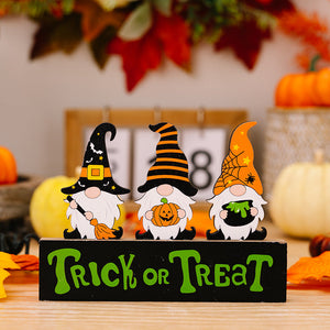 Halloween gnome trio display with pumpkins and brooms on a Trick or Treat sign.