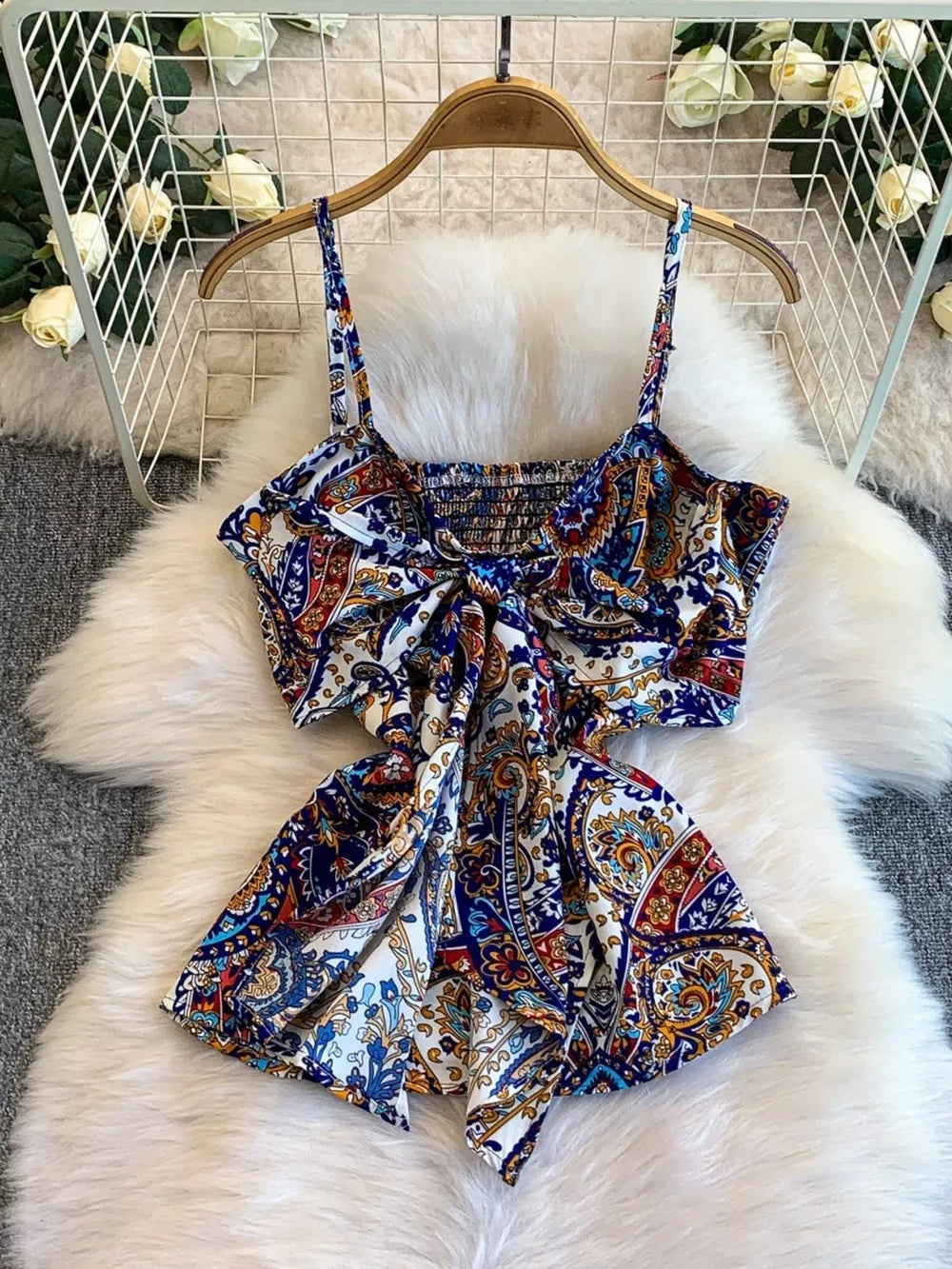 Chic cami with paisley print, smocked bodice, and tie-front detail.