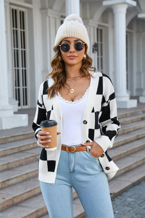 Checkerboard knit V-neck cardigan in black and white acrylic with button front and ribbed trim.