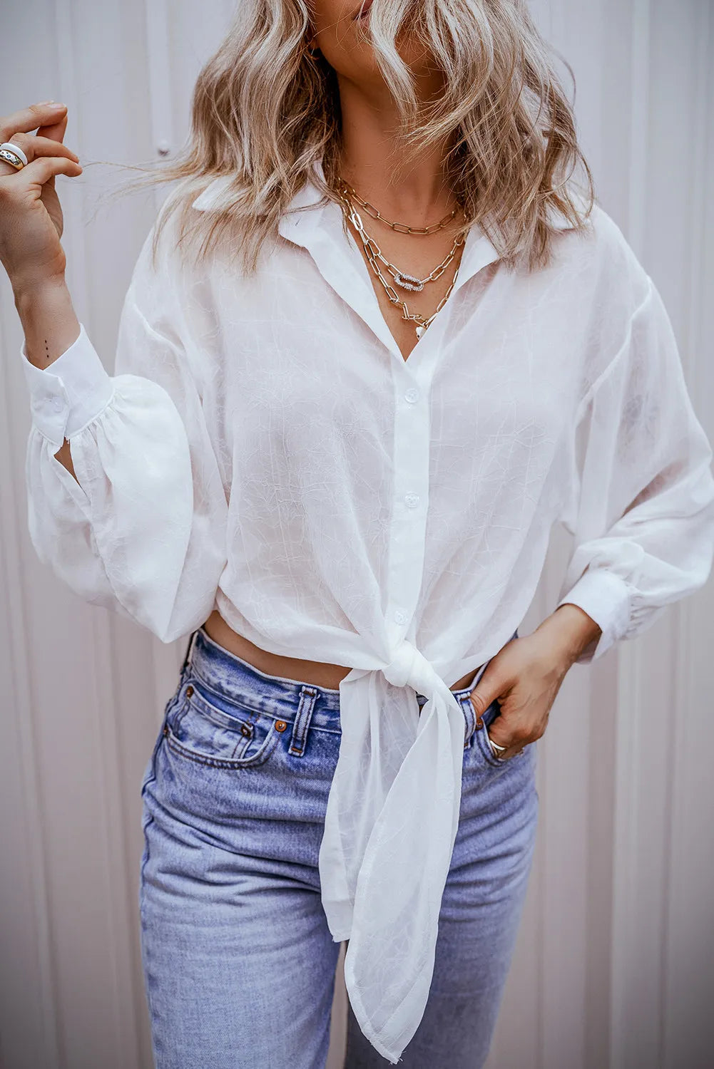 White sheer tie-front blouse with gathered sleeves and subtle texture.