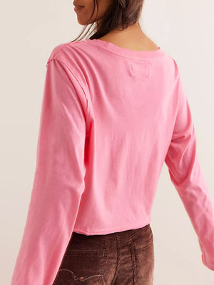 Pink long sleeve crop top with raw hem and crew neck.