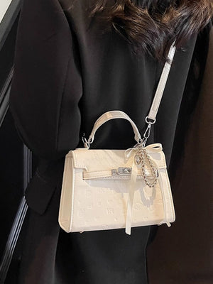Ivory embossed mini pu leather crossbody bag with ribbon and charm detail