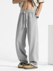 Men's grey sweatpants with drawstring waist and pockets.