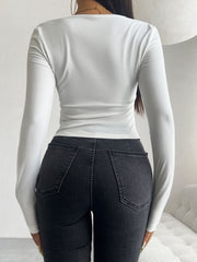White ruched bustier long sleeve top with a square neckline.