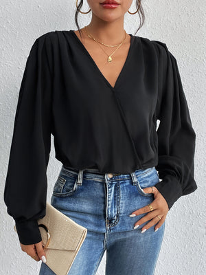 Black surplice bodysuit with balloon sleeves and a deep V-neck, styled with jeans.