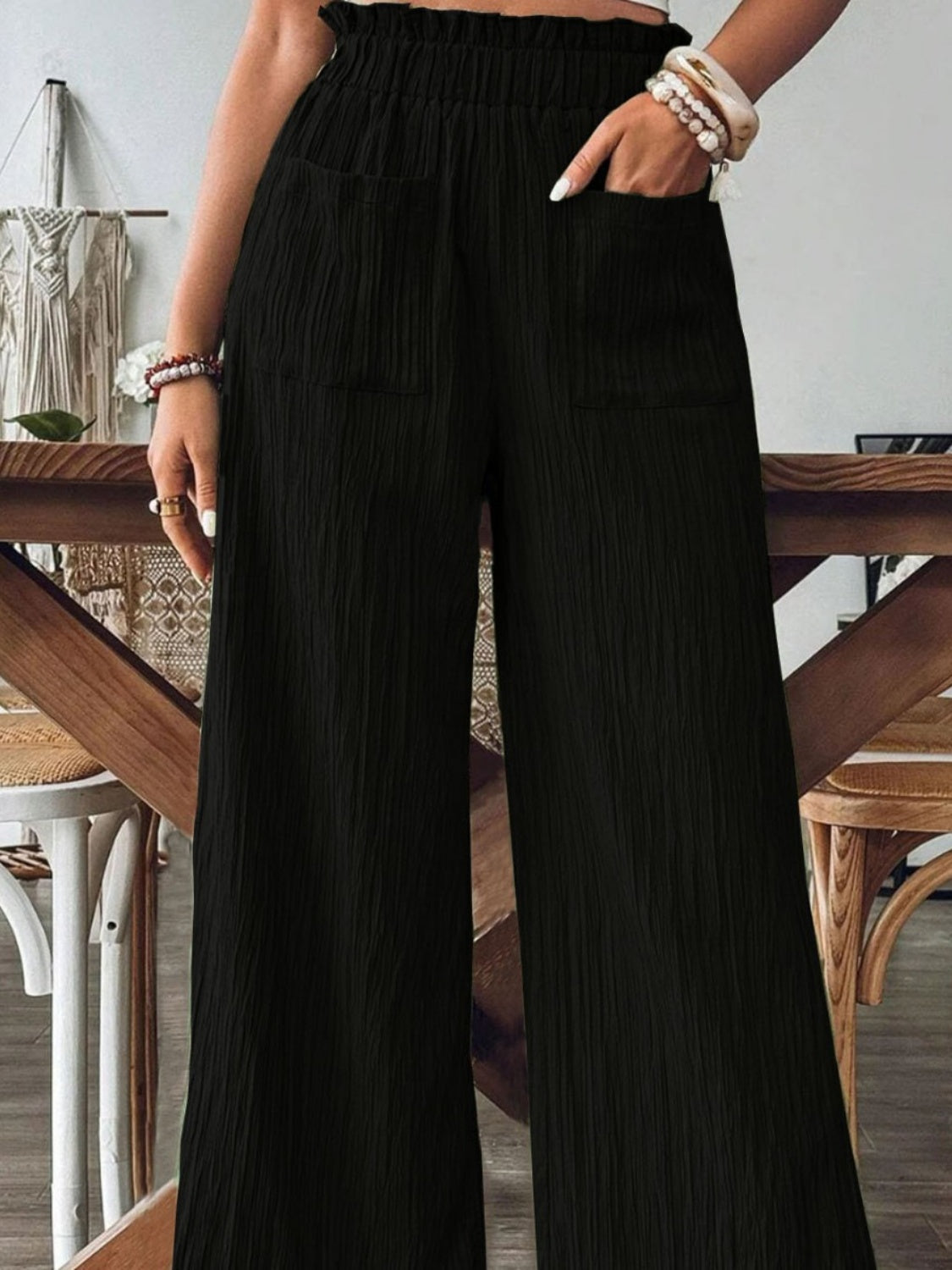 Black textured wide-leg palazzo trousers with elastic waist and pockets.
