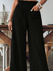 Black textured wide-leg palazzo trousers with elastic waist and pockets.