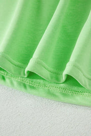 Embroidered eyelet two-piece set in bright green cotton with drawstring pants detail.