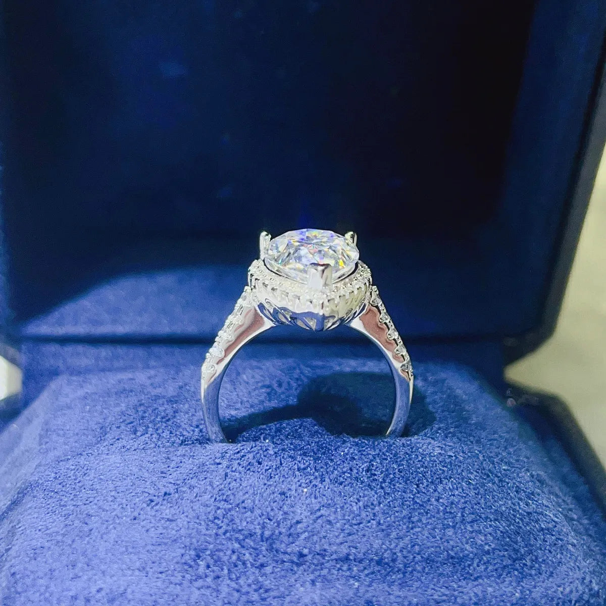 White halo engagement ring with pear-cut center stone and diamond band