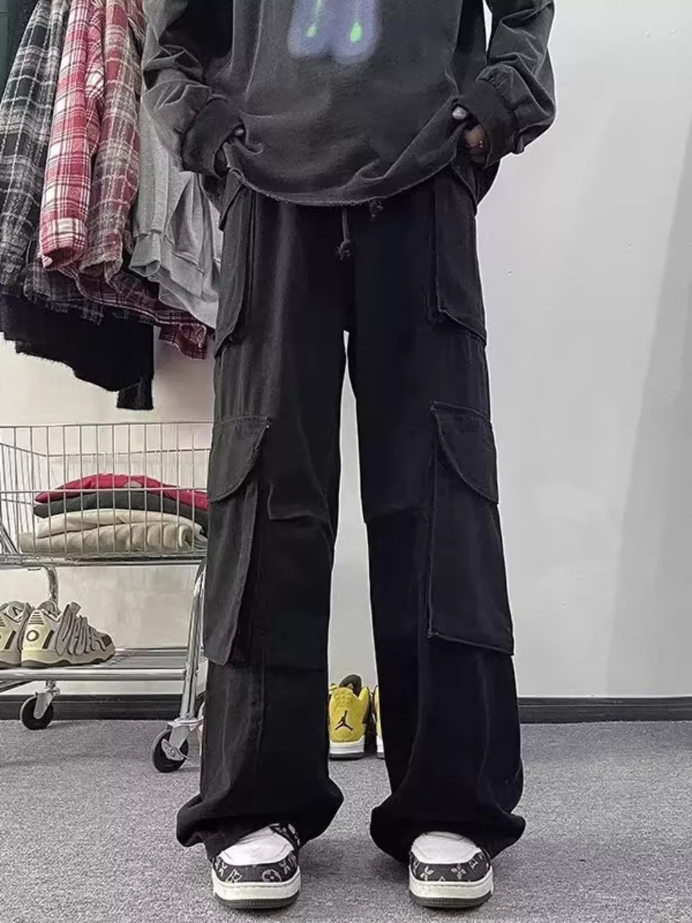 Black cargo pants with multiple large pockets and a drawstring waist.