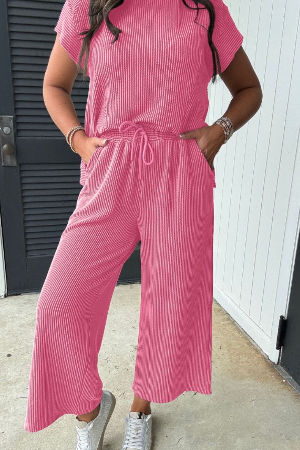 Ribbed knit drawstring co-ord set in fuchsia pink with cropped wide-leg pants and short sleeves.