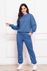 Relaxed fit crewneck sweatshirt and jogger pants set in dark blue with elastic cuffs and waistband.