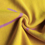 Banana yellow knit midi dress with pink swirl print and halter neckline detail.