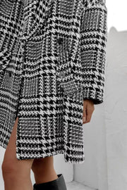 Oversized houndstooth cocoon coat in black and white with double-breasted closure and side slit.