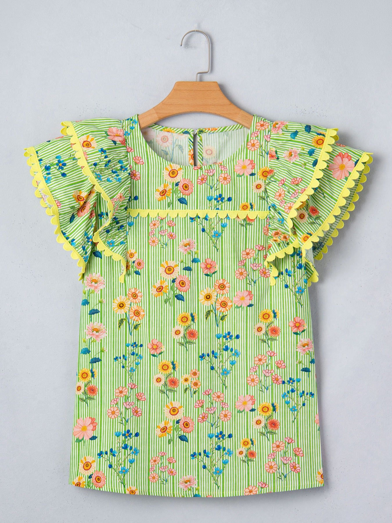 Green striped cotton blouse with floral print, ruffle sleeves, and yellow trim.