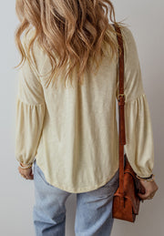 Pastel yellow blouse with embroidered poet sleeves and a rounded hem.