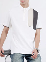 White cotton polo shirt with asymmetrical color-block detail on shoulder and black trim sleeves.