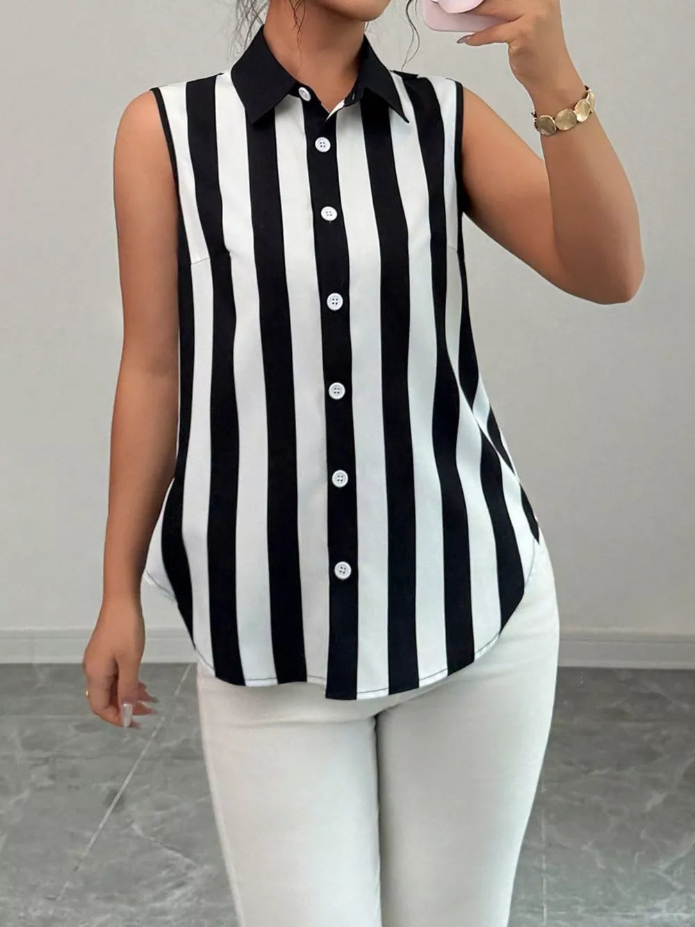 Sleeveless collared shirt with black and white stripes and button front.