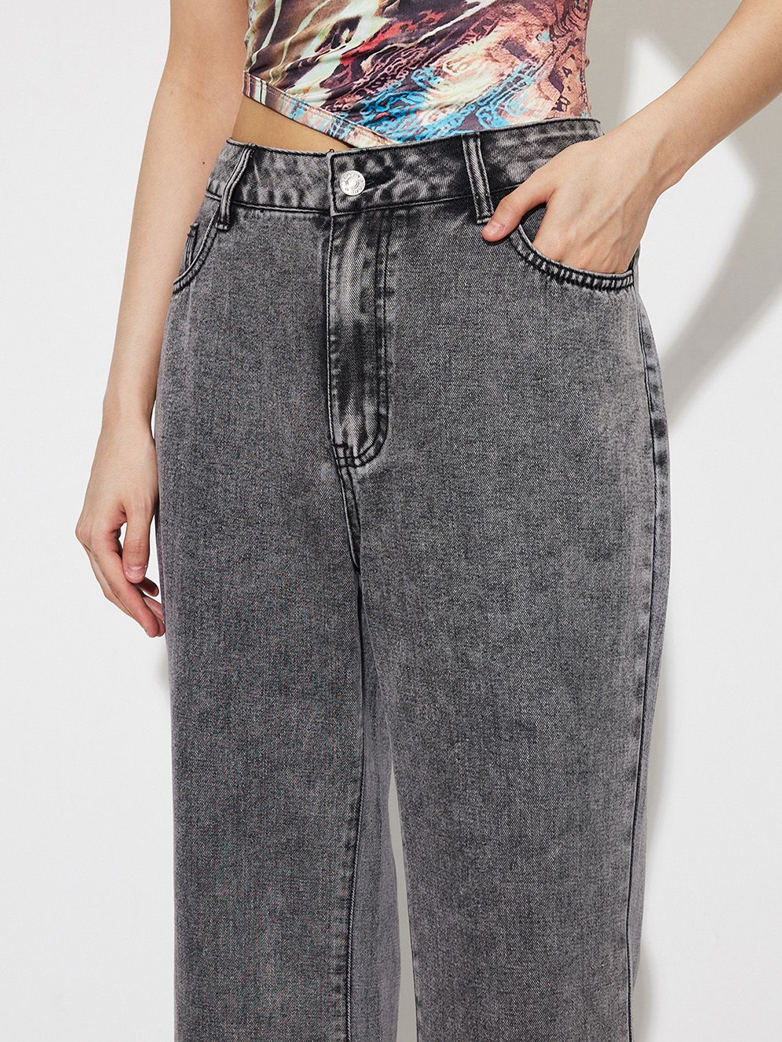 Acid wash high-rise flare jeans in dark gray cotton with button fly and pocket detail.