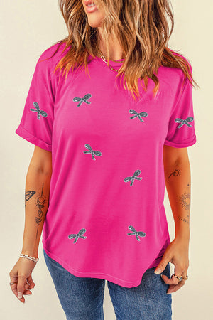 Hot pink t-shirt with embroidered bows and rolled sleeves.