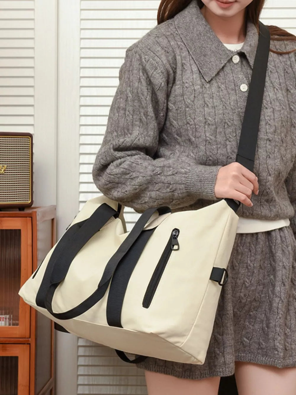 Beige Oxford cloth travel bag with black accents and zipper detail