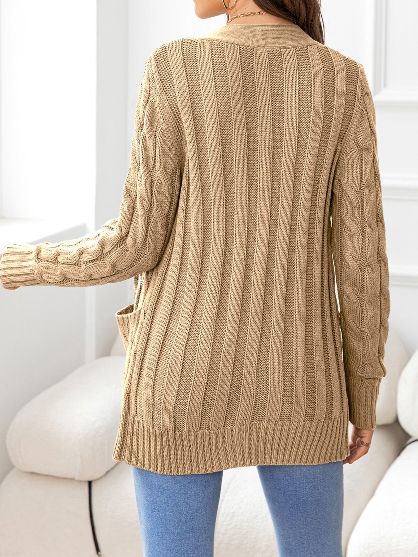 Camel knit cardigan with cable sleeves and ribbed texture.