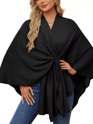 Black knit cape top with tie-front detail and draped elegance, V-neck, relaxed fit.