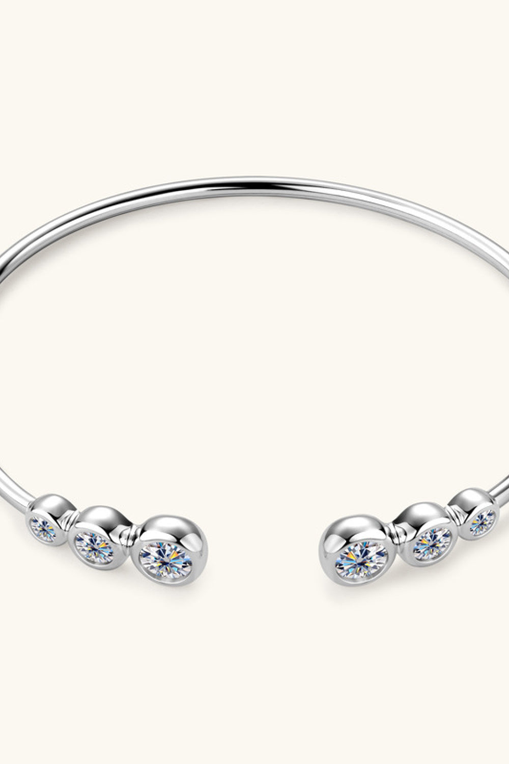 Silver open-ended cuff bracelet with bezel-set moissanite stones and polished spheres.