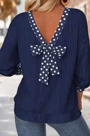 Navy polka dot bowknot backless blouse with ribbed texture and long sleeves.
