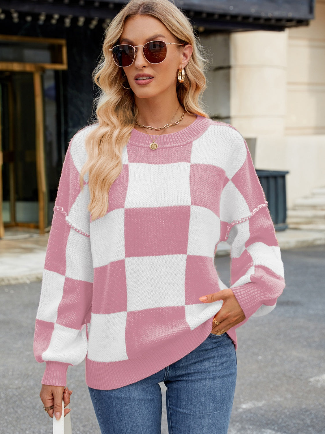 Checkerboard knit sweater in blush pink and white with balloon sleeves and crew neck.