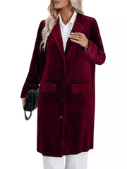 Burgundy velvet longline trench coat with lapel collar, buttoned front, and flap pockets.