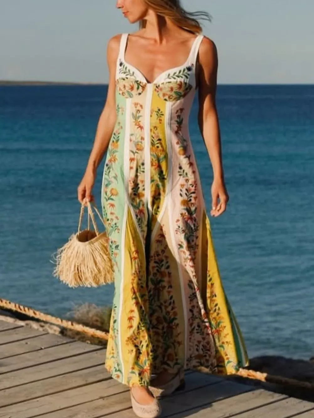 Botanical print sweetheart maxi dress with vertical stripes in pastel colors and a flowing skirt.