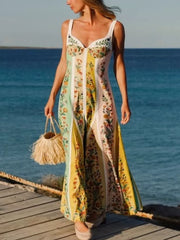 Botanical print sweetheart maxi dress with vertical stripes in pastel colors and a flowing skirt.