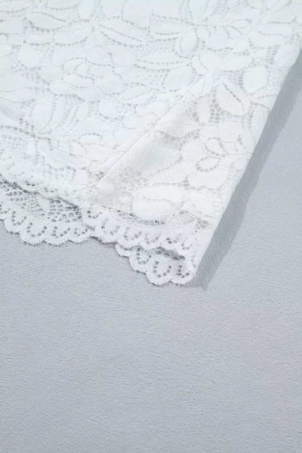 White lace blouse with ruffled hem detail
