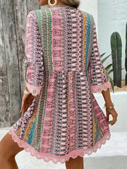 Bohemian pink printed v-neck dress with bell sleeves and lace trim.