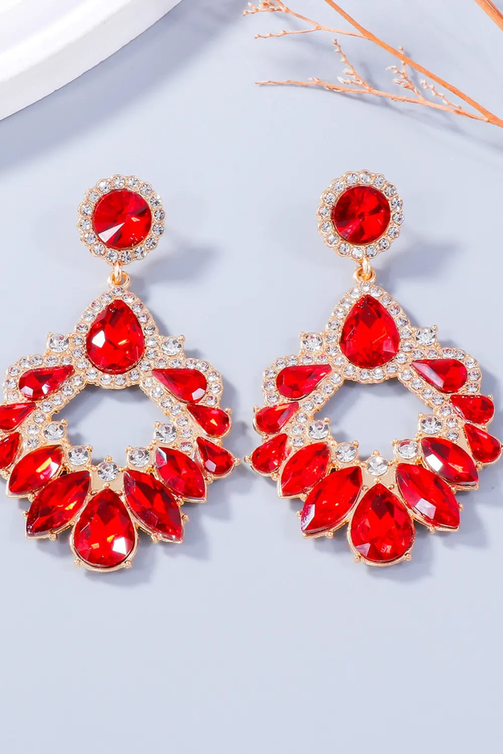 Red crystal drop earrings with gold alloy setting and floral-inspired design.