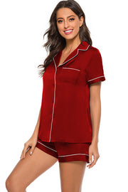 Scarlet satin pajama set with white piping, button front top and shorts.