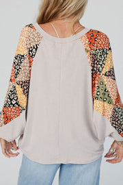 Patchwork raglan sleeve top in light gray with colorful leopard print panels.