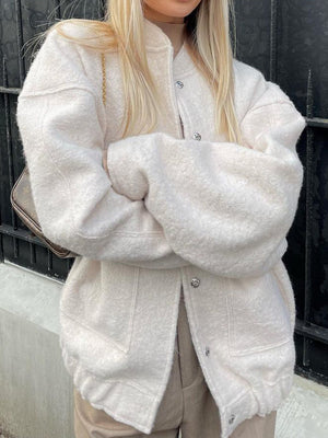 White boucle cocoon jacket with snap closure and rounded collar.
