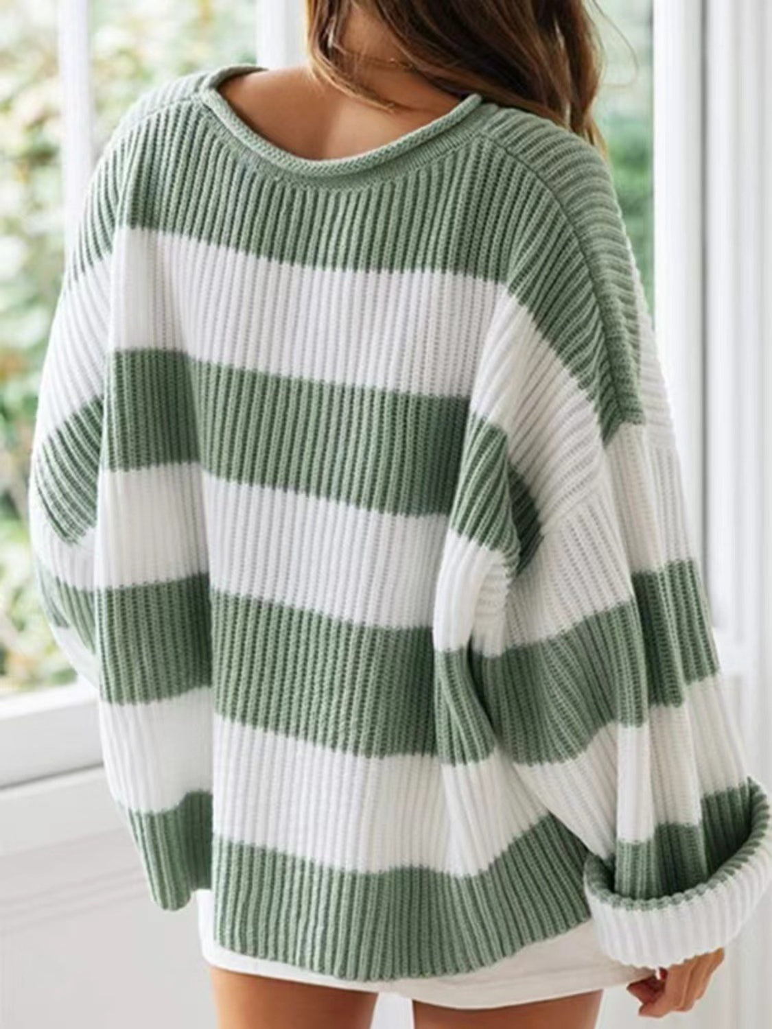 Striped oversized knit sweater in sage green and white with a crew neck.