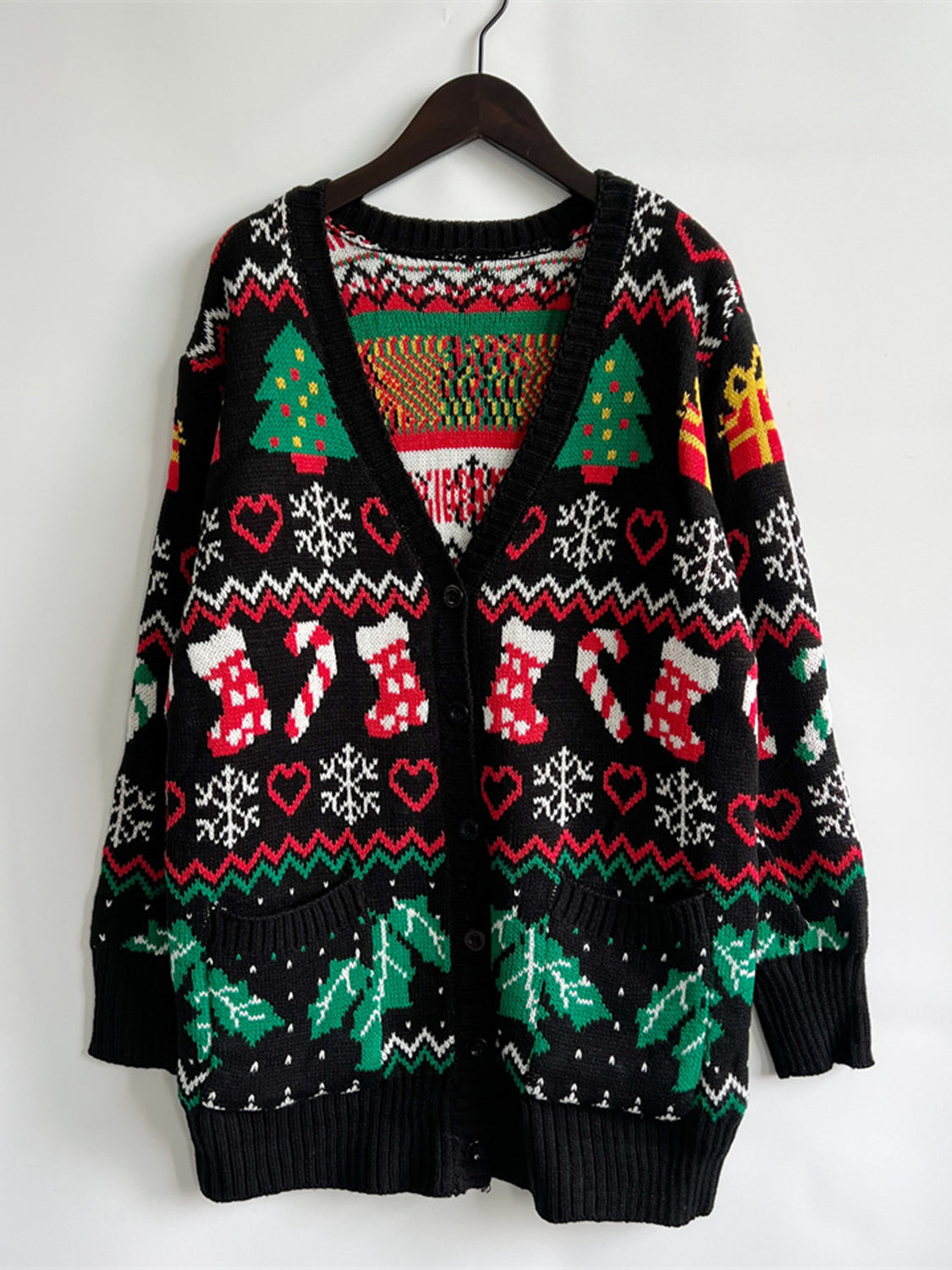 Black acrylic Fair Isle knit cardigan with Christmas trees, stockings, snowflakes, and holly.