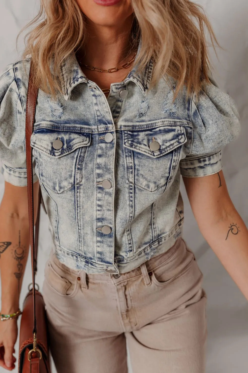 Cropped denim bolero jacket in medium wash with puff sleeves and distressed details.