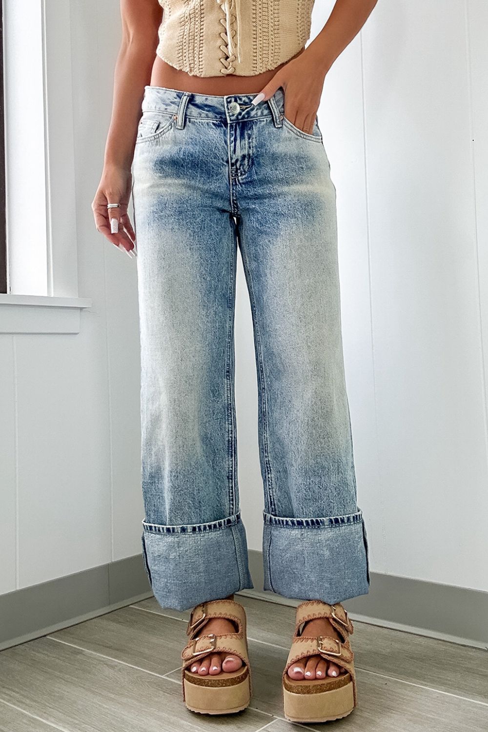 Medium washed denim jeans with wide cuffed hems and a relaxed fit.