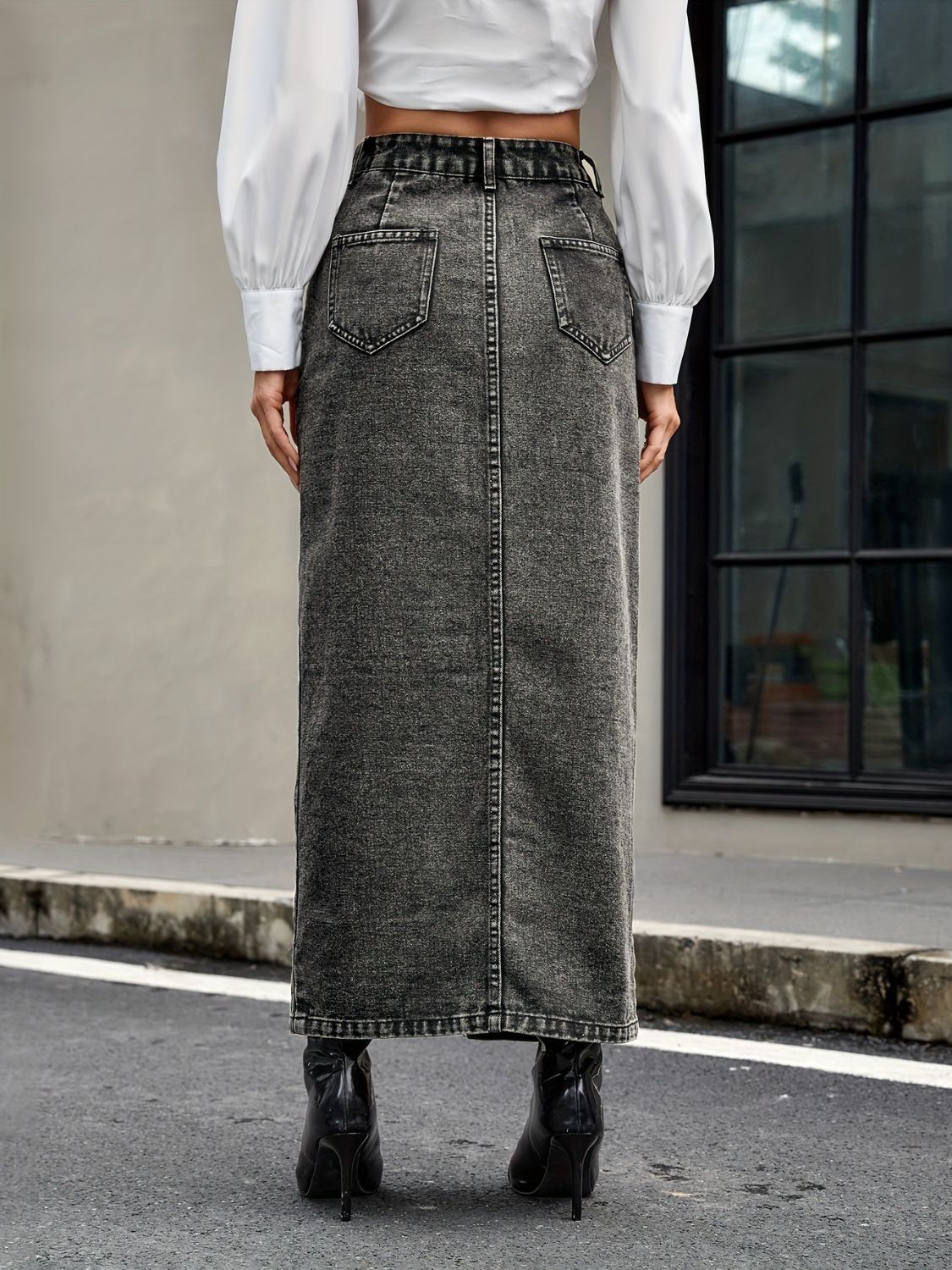 Dark gray denim maxi skirt with button front and slit, styled with a white shirt and black boots.
