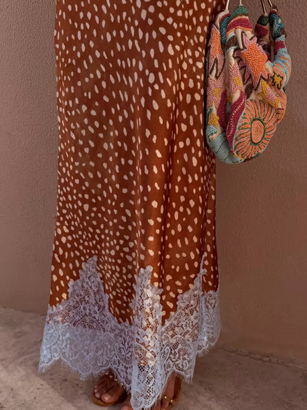 Brown polka dot skirt with white lace trim, styled with a beaded bag.
