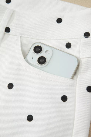 White chino shorts with black polka dots and a phone in the pocket.