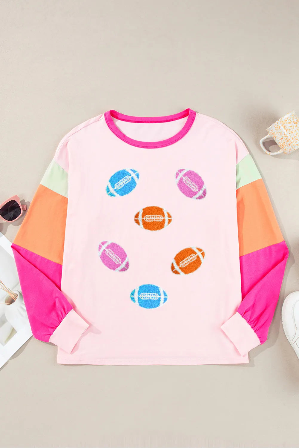 Colorblock long sleeve t-shirt in blush pink with football graphics and contrast sleeves.
