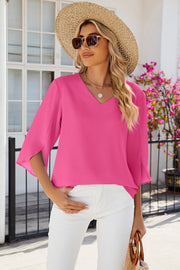 Hot pink v-neck blouse with asymmetric split sleeves and a relaxed fit.