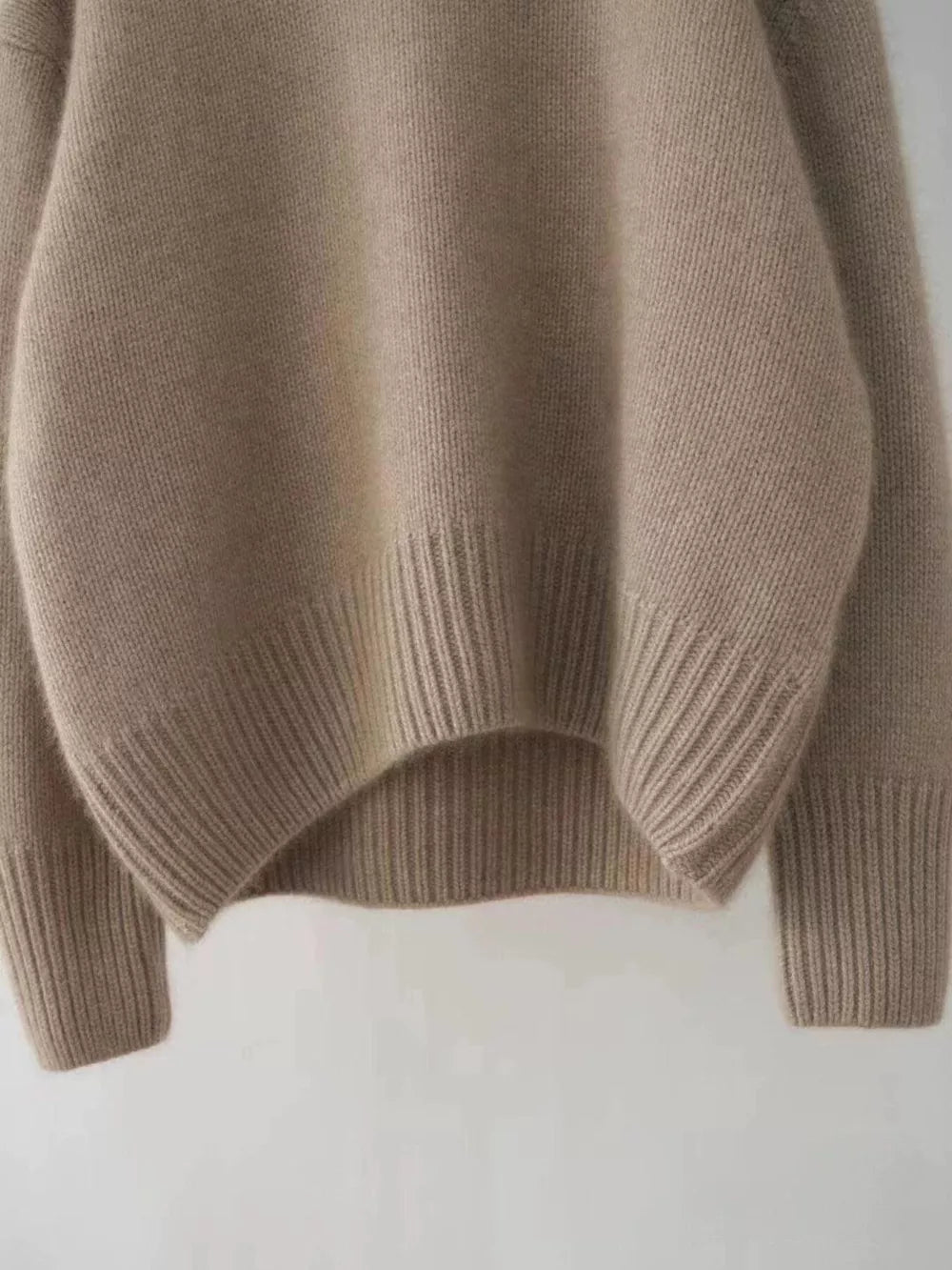 Cozy beige acrylic knit sweater with dropped shoulders and ribbed cuffs and hem.